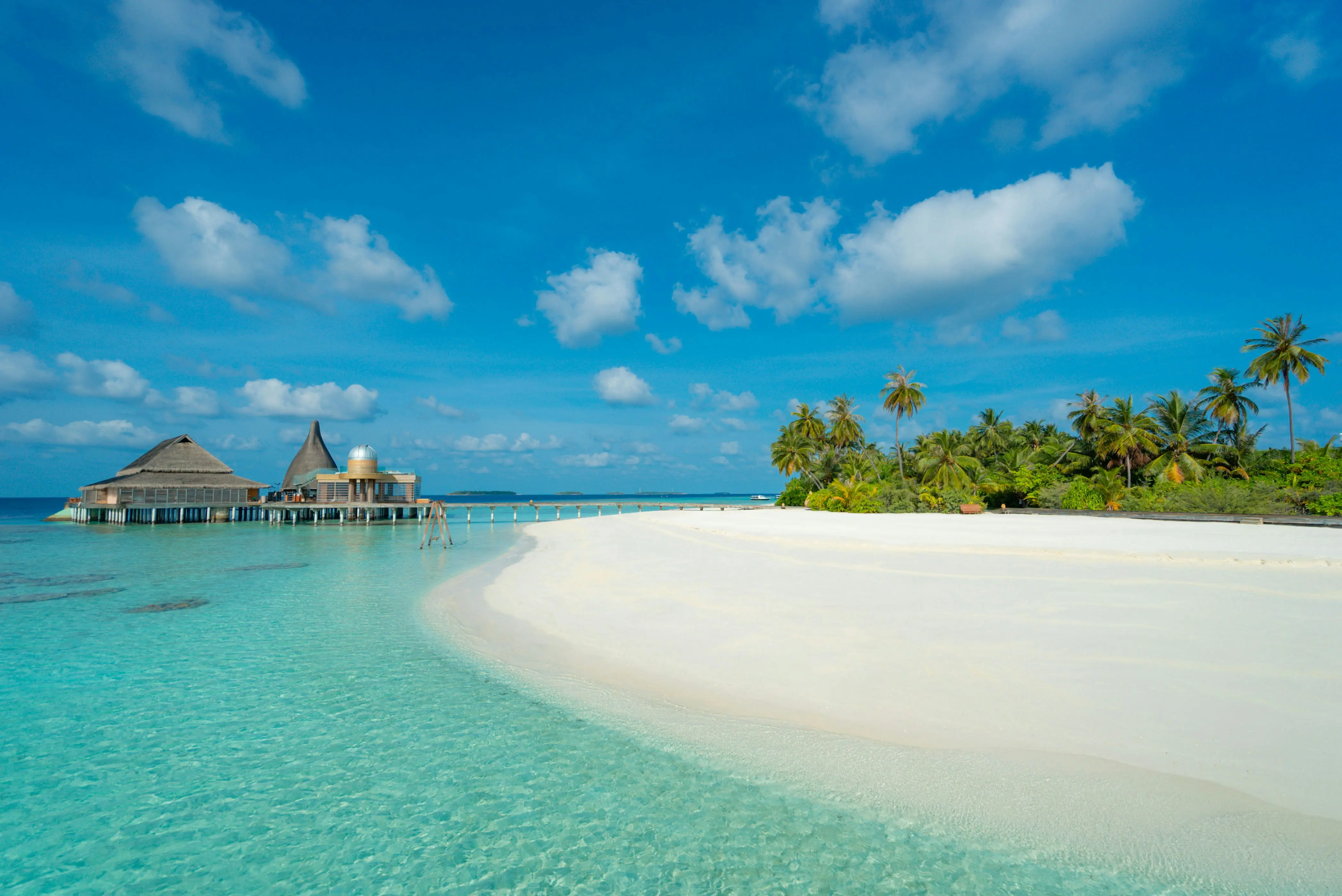 A white sandbank and an overwater restaurant at a Maldives resort