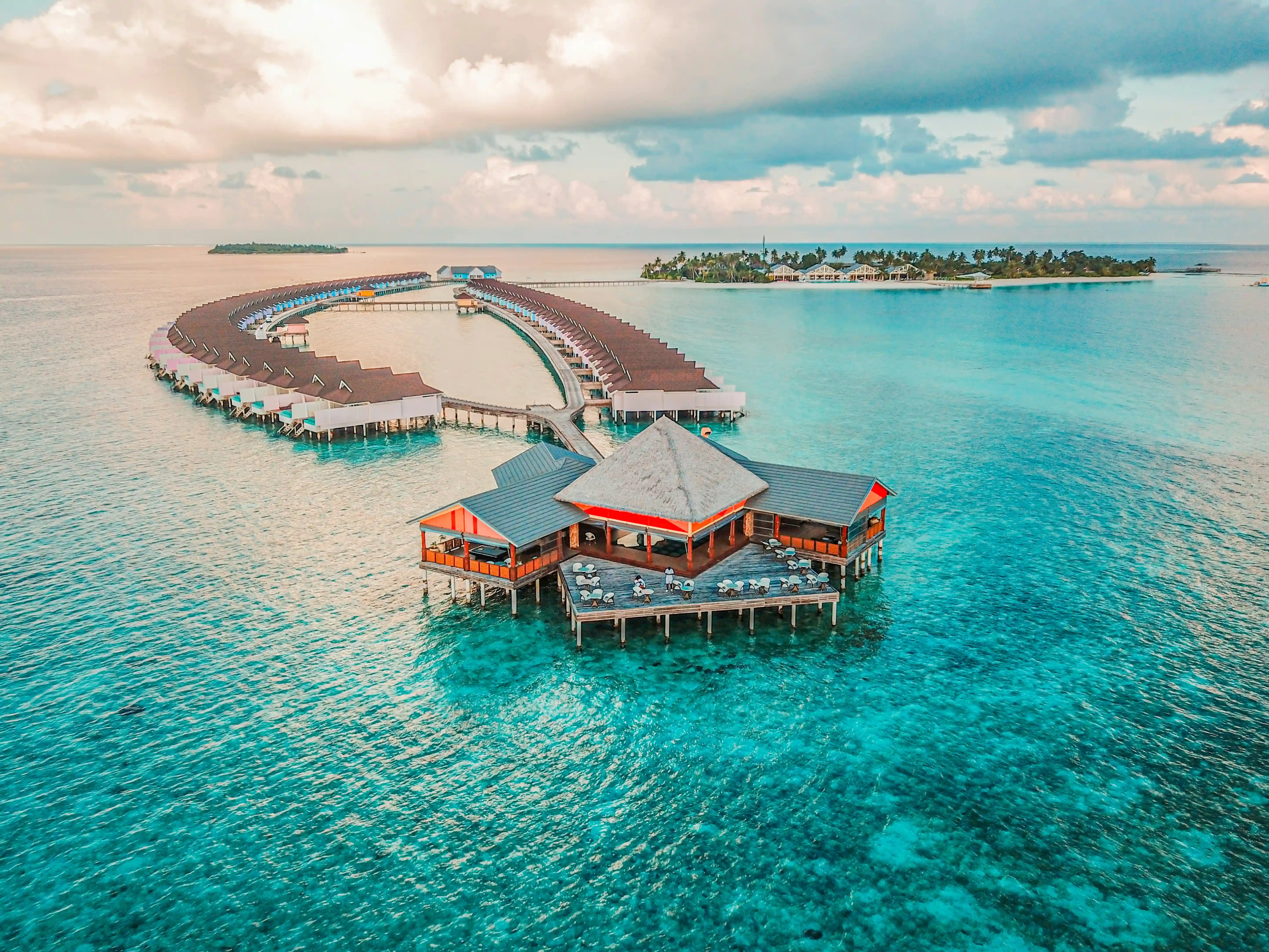 An overwater restaurant and water villa jetties in a Maldives lagoon