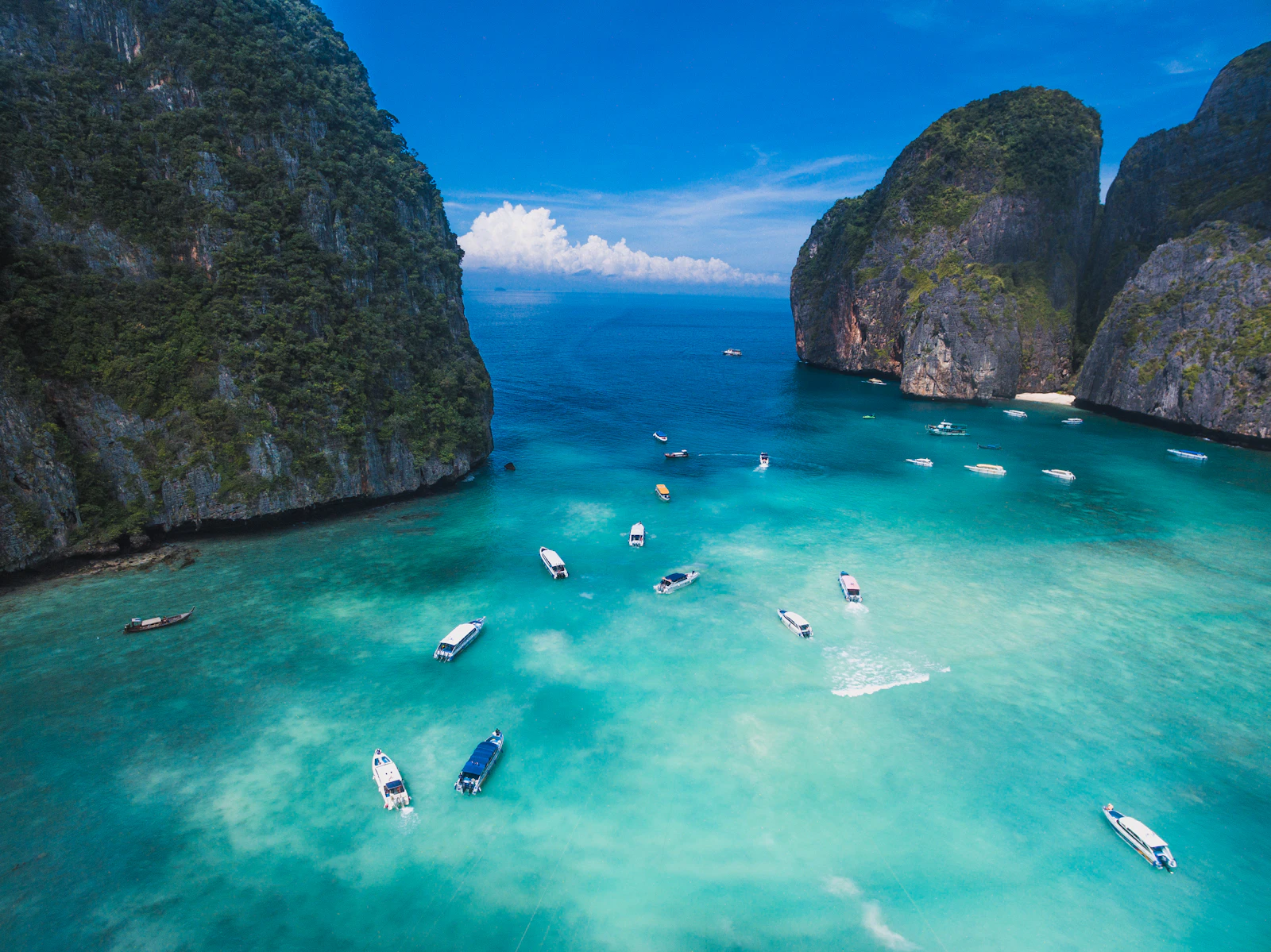 Boats on the turquoise water of Maya Bay between limestone cliffs