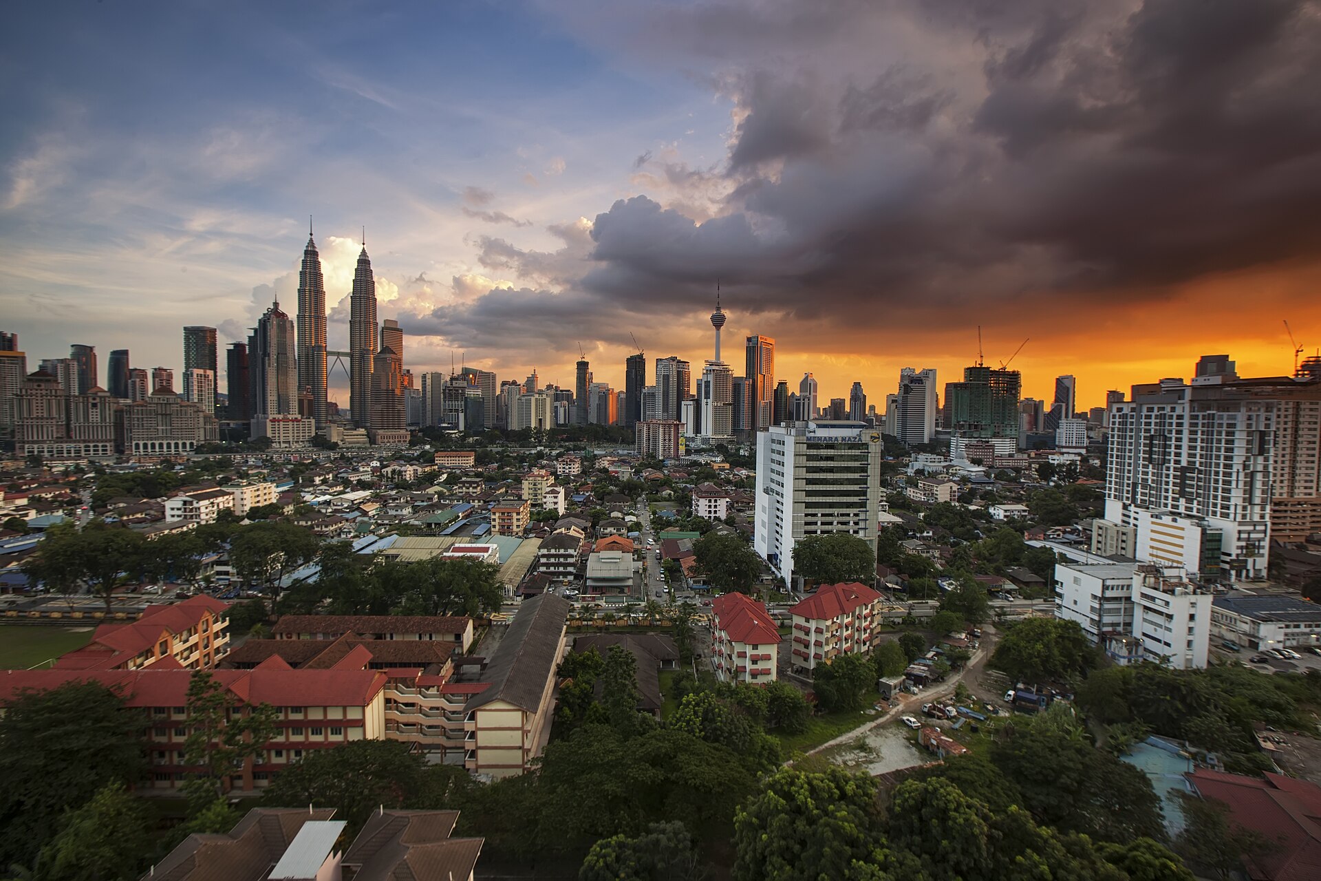 The Kuala Lumpur skyline at sunset, with the Petronas Twin Towers and KL Tower